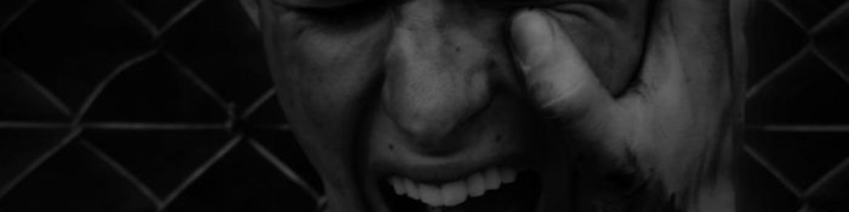 A young man's anguished shout captured in a dramatic black and white composition.